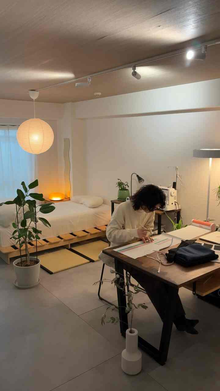 White and wood-tone studio apartment home office featuring desk and bed in a serene Wa-Modern style room