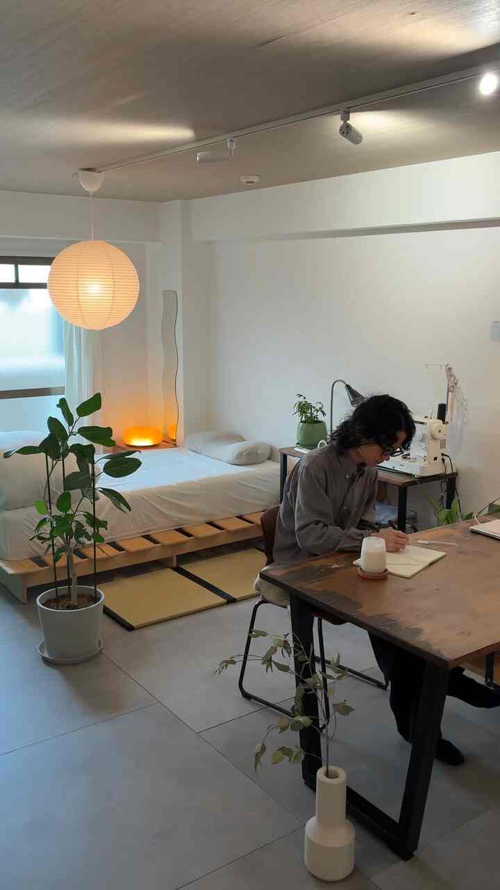 Natural modern toned studio apartment featuring single bed, desk, and plants with a clean study and relaxation atmosphere