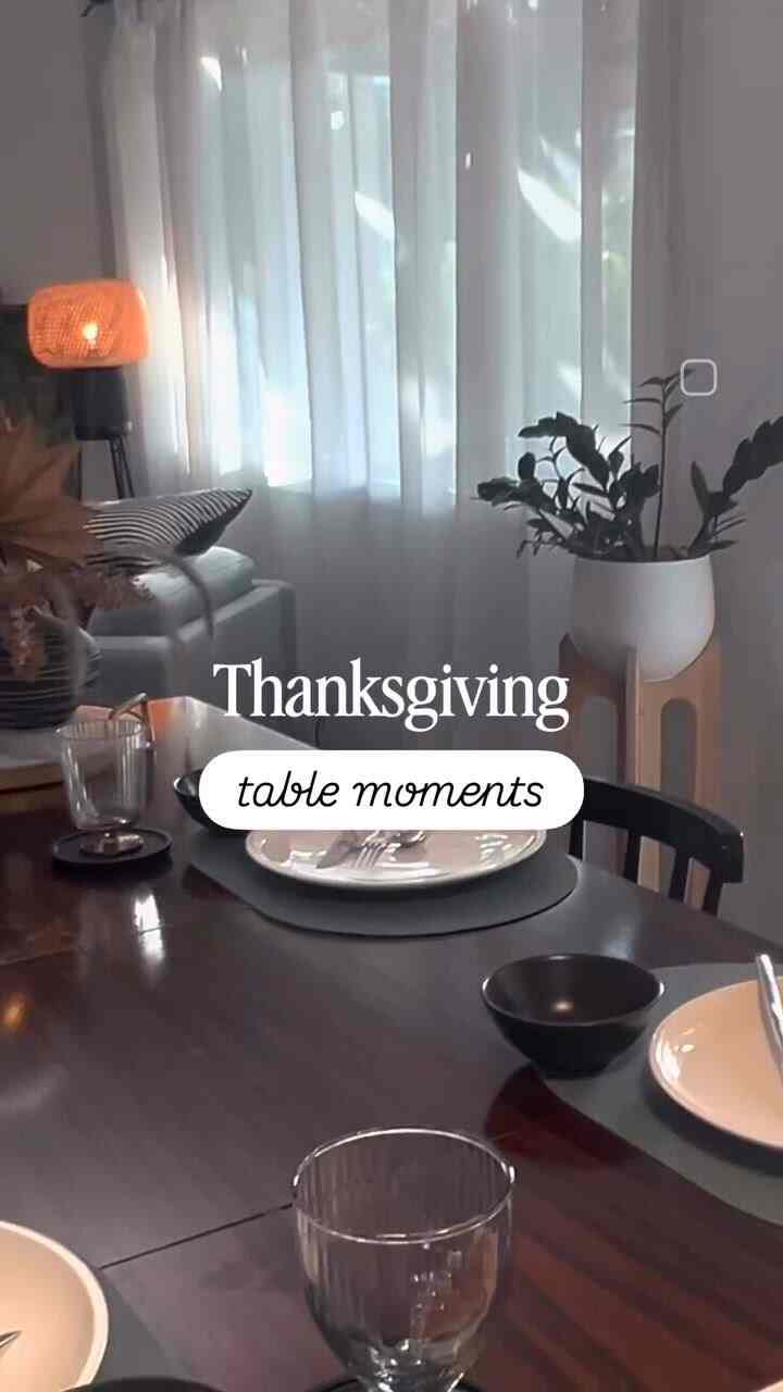 Modern cozy dining room featuring white curtains, dark brown dining table with neatly set plates and cutlery