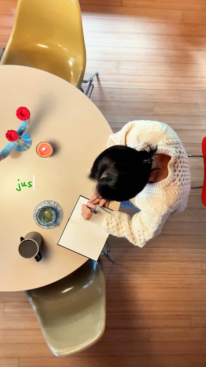 Warm wood tone natural material single household home office space featuring a round dining table and two dining chairs with cozy atmosphere