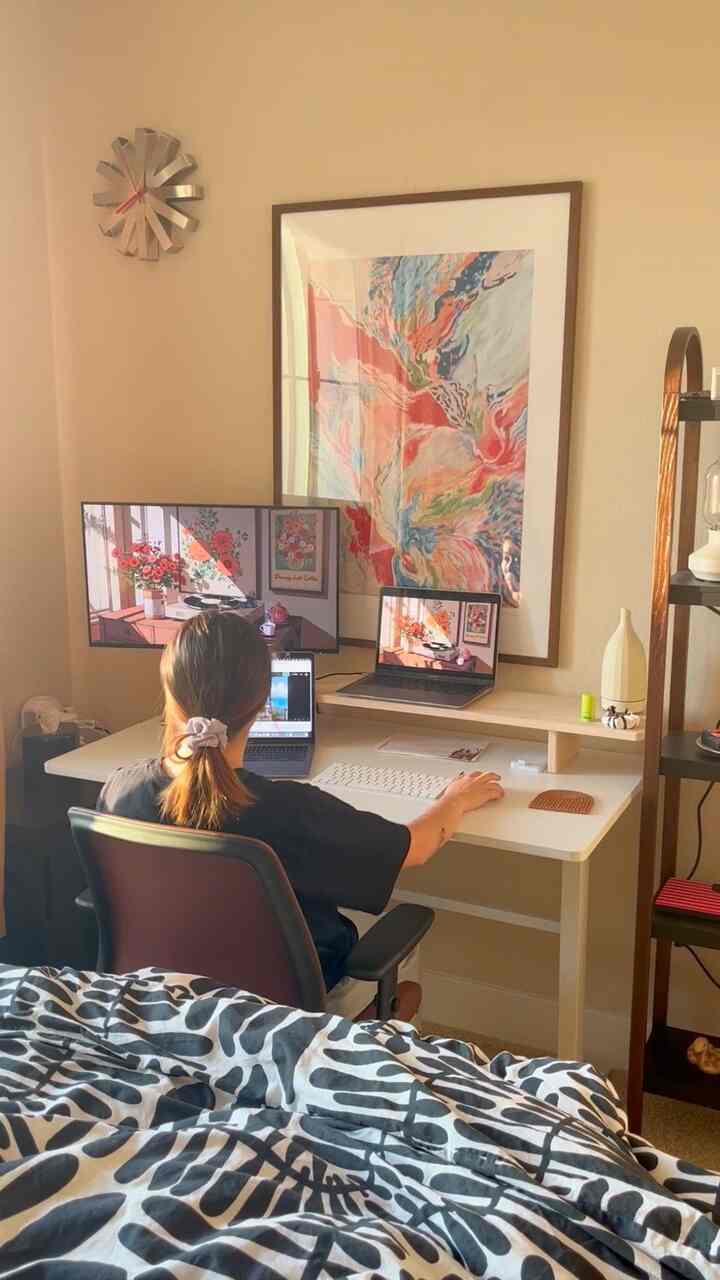 Beige-walled bedroom home office featuring a white desk, modern office chair, and cozy atmosphere