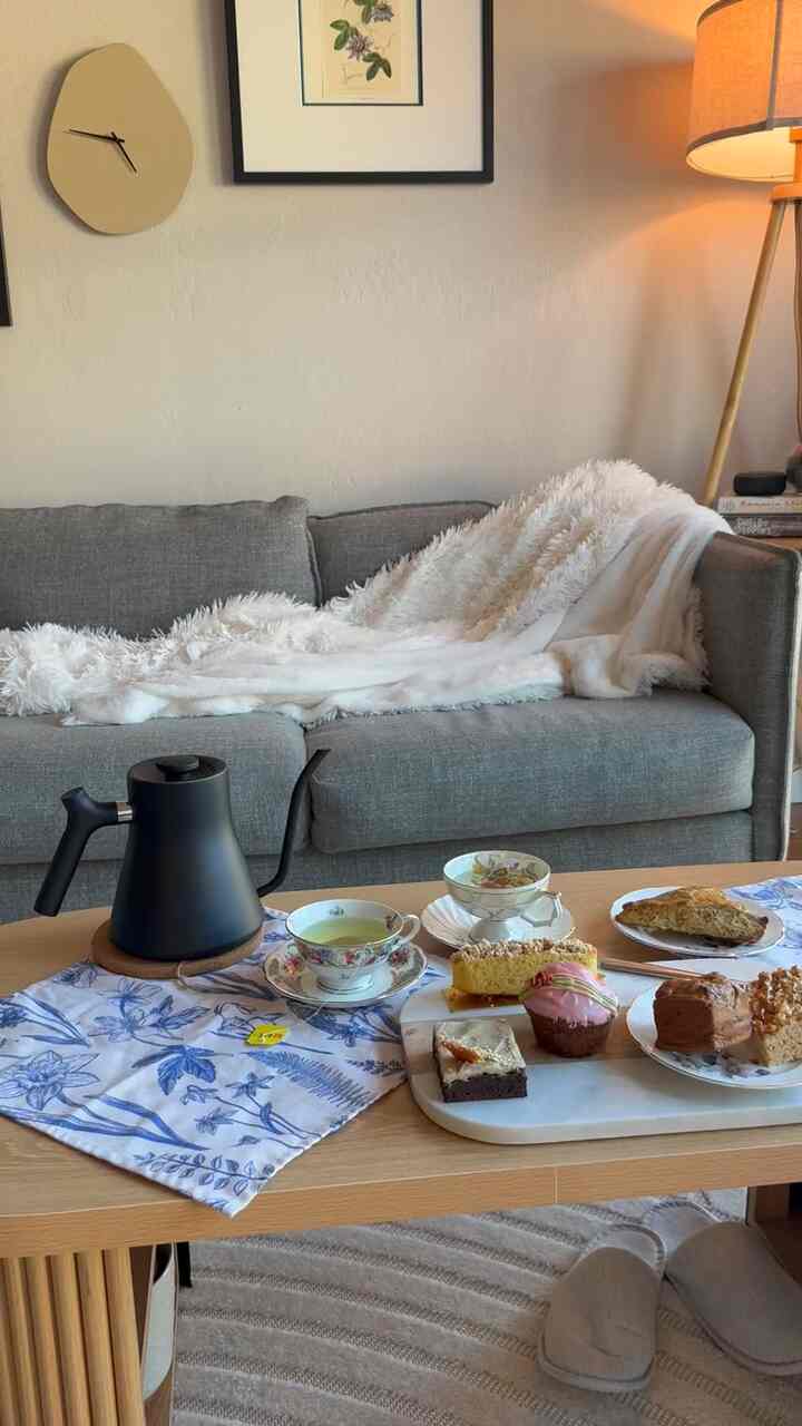 Beige wall and gray sectional sofa living room featuring wooden coffee table with home cafe accessories and cozy ambiance