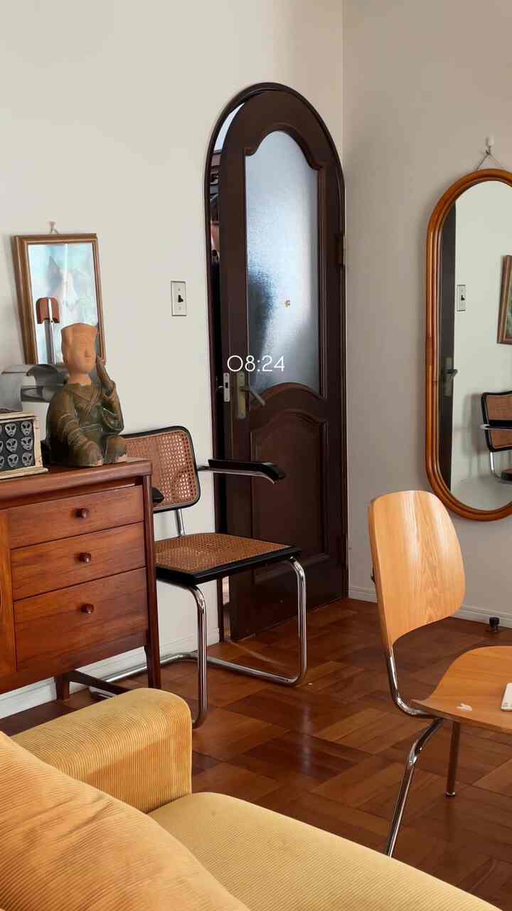 ベージュと木目調のリビング、ソファと木製家具、大きな鏡が配置された温かみのあるインテリア