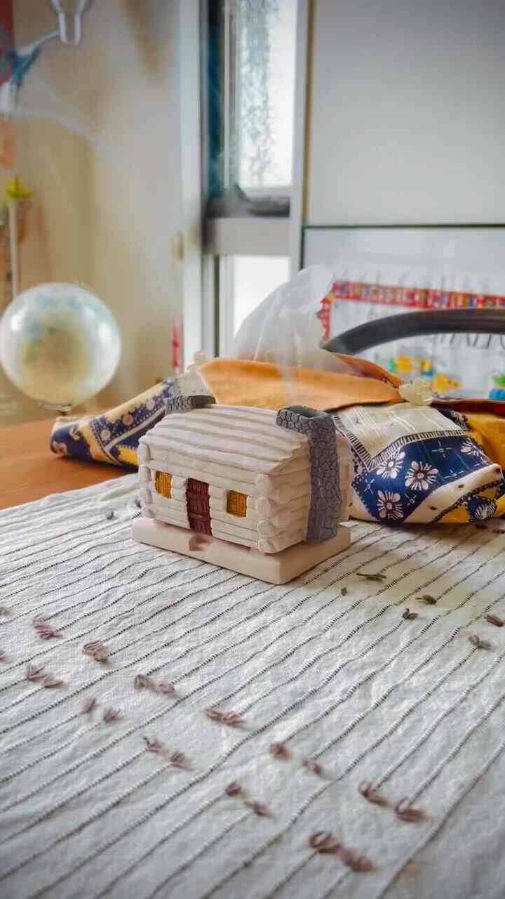 白と木目調の調和がとれたミッドセンチュリーモダンのリビング、かわいらしいオブジェとテーブルクロスが配置された雰囲気のある空間