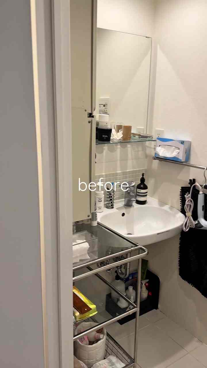 白を基調としたバスルーム、鏡とキャビネットが配置された印象的でモダンな空間