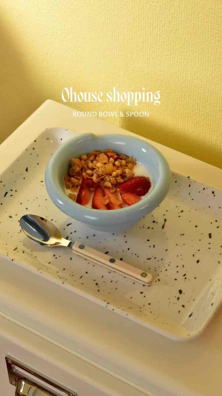 明るい黄色の壁と白い皿の上にパステルブルーのボウルと小さなスプーンが置かれたキッチンの雰囲気のある空間