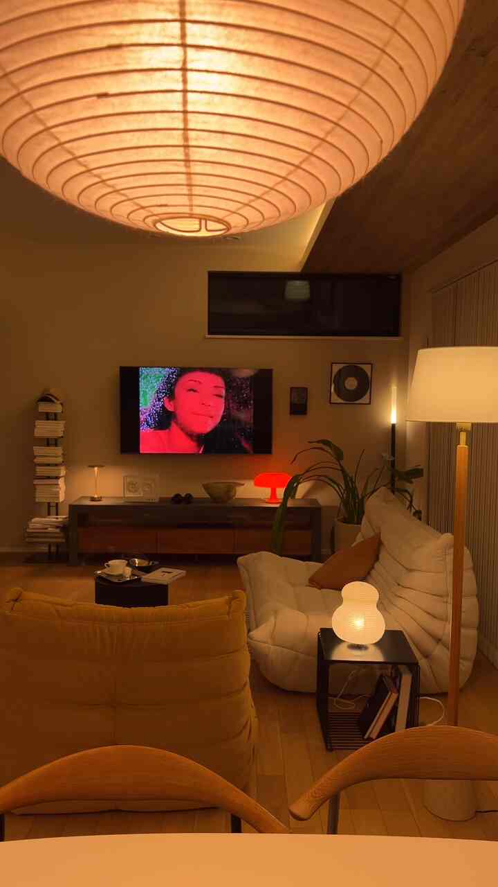 Warmly lit modern long and narrow living room featuring sofa and floor lamp arranged for cozy atmosphere