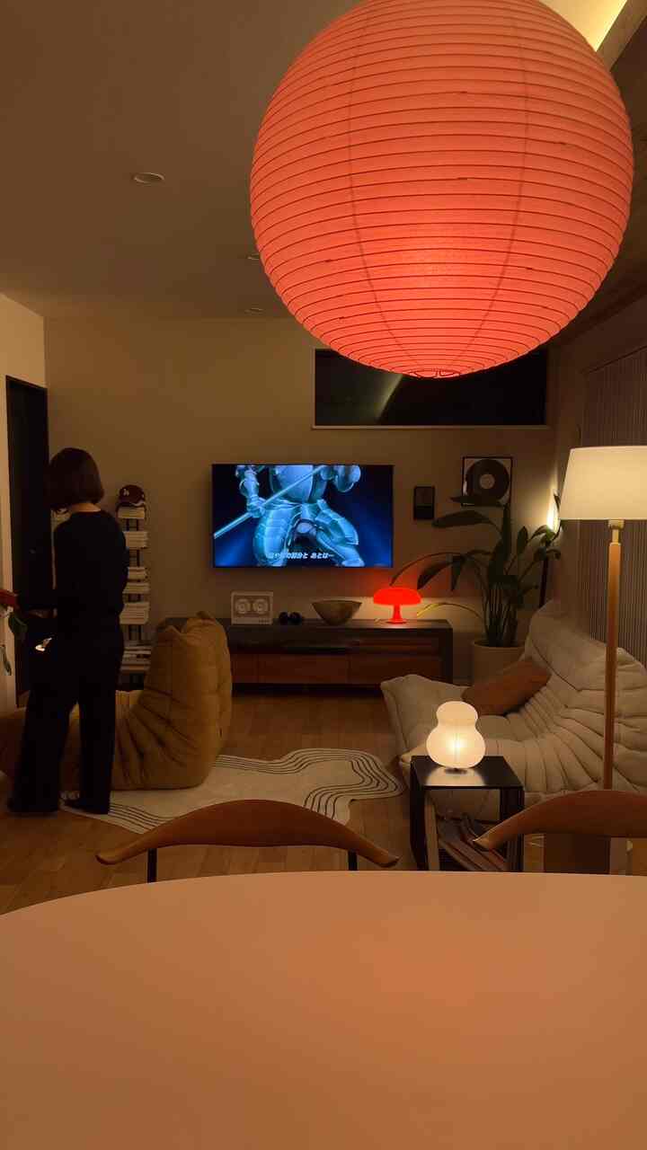 Beige walls and wood tone floor living room featuring white sofa and various ambient lamps creating a cozy atmosphere