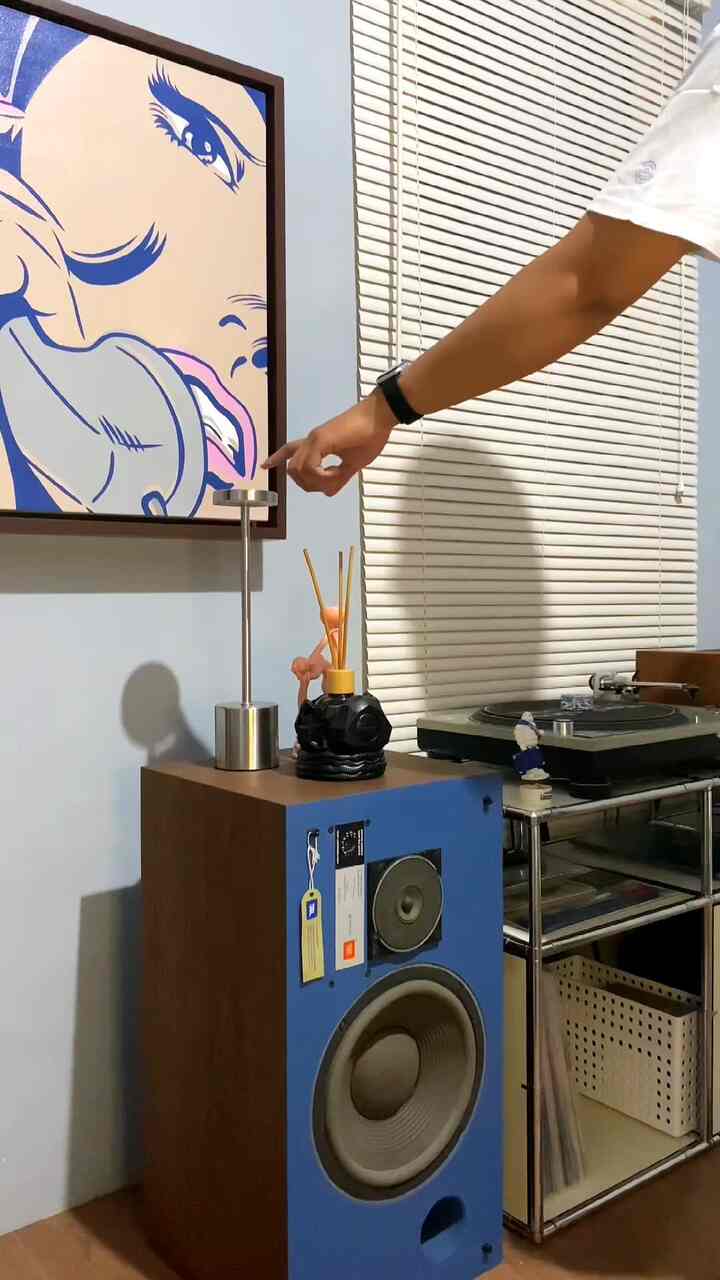 Blue and wood-toned space featuring a vintage speaker and white blinds in a modern living room interior