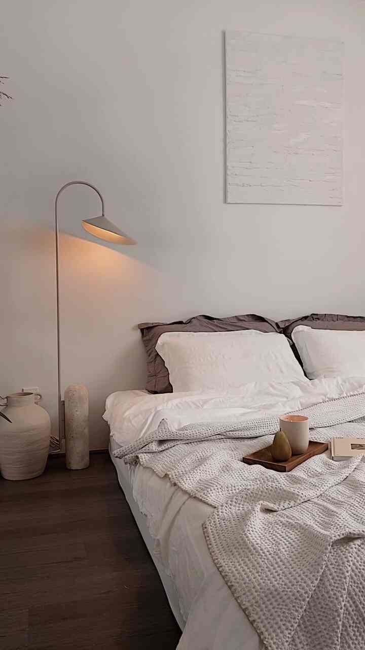 A calm, neutral-toned bedroom interior. 

#bedroom #bedroominterior #bedroomdecor #bedding #lightinginterior #lighting #lamp #vase #candle #woodtray #canvasframe #pillowcover #neutralinterior #neutral 