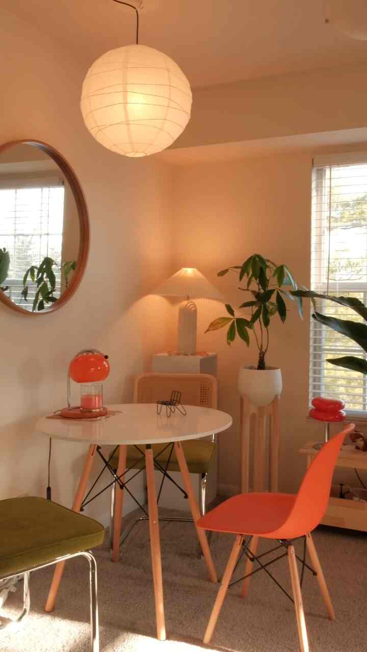 Warm wood tones and orange accents in a dining room featuring various lamps and plants creating a cozy atmosphere