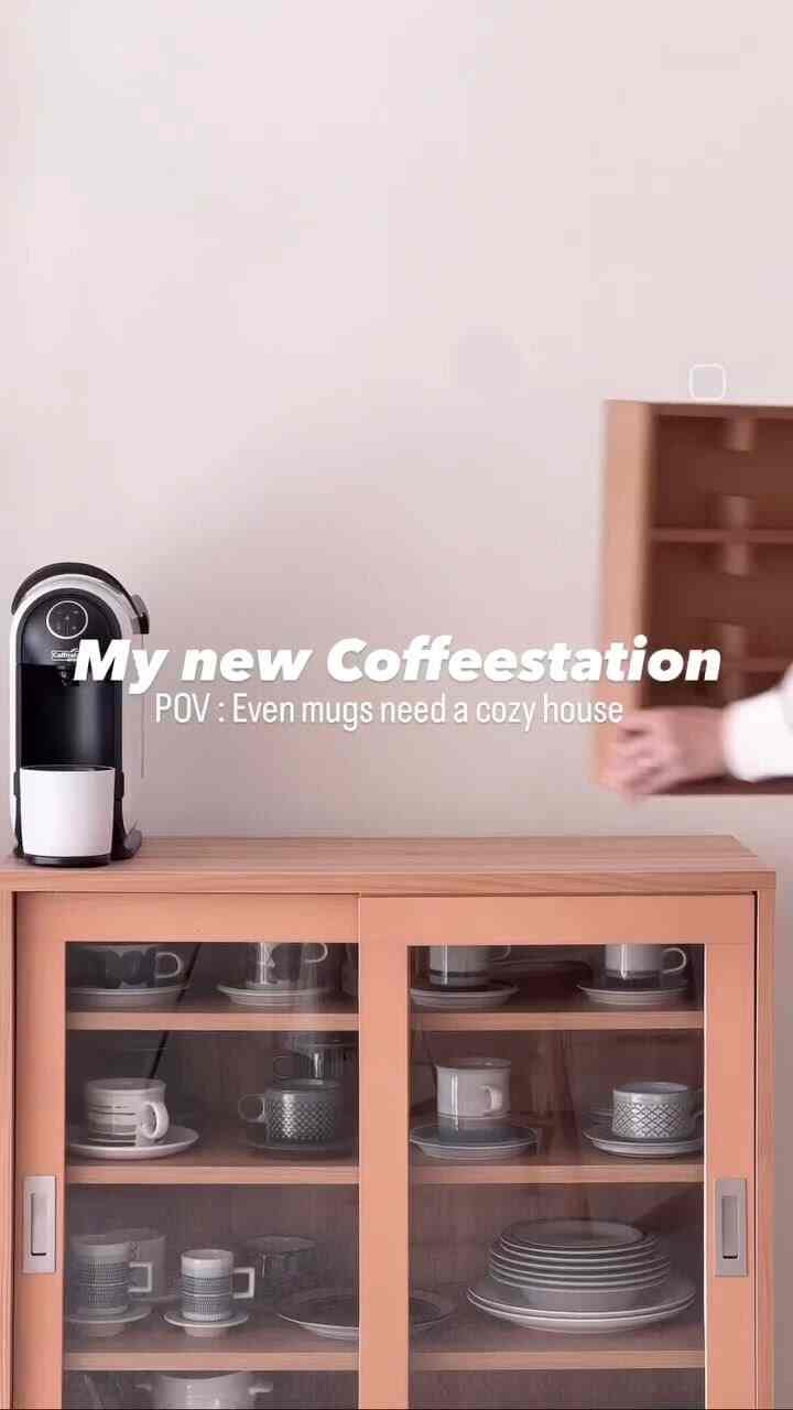 Natural wood tone kitchen area featuring glass-door cabinet neatly storing coffee cups and plates in a cozy home cafe setup