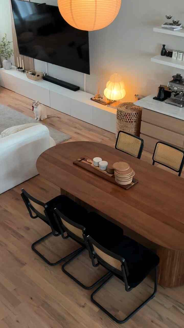 Warm wood-toned dining room featuring a four-seat dining table and a cat, creating a cozy natural atmosphere