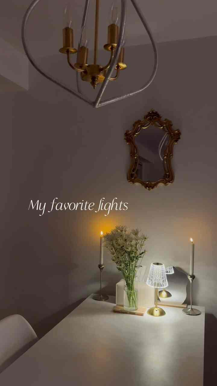 White table and gold candle holders in a dining room, featuring candlelight and table lamp for warm romantic ambiance