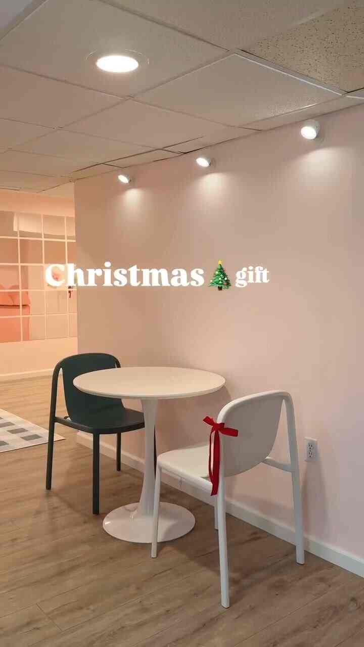 White and red toned small dining table with chairs in a simple, cozy basement interior