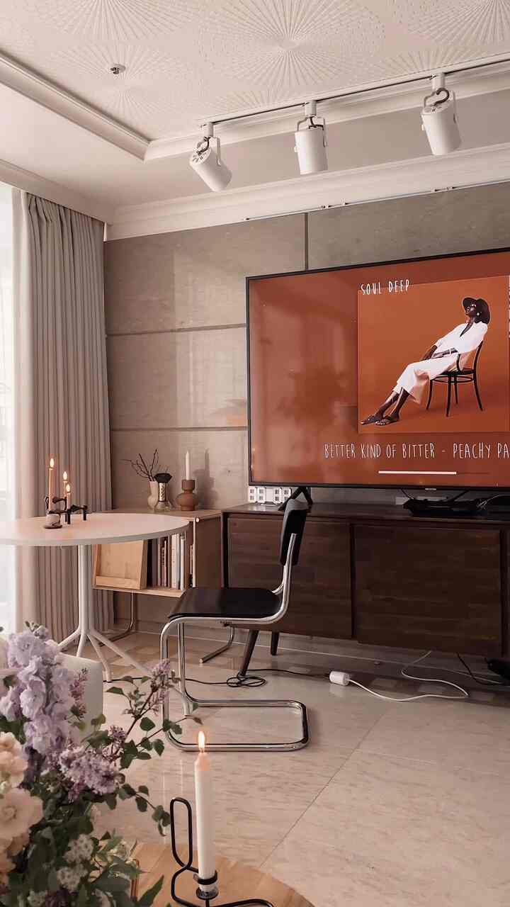Beige-toned living room featuring brown sideboard and black chair in a modern and natural setting