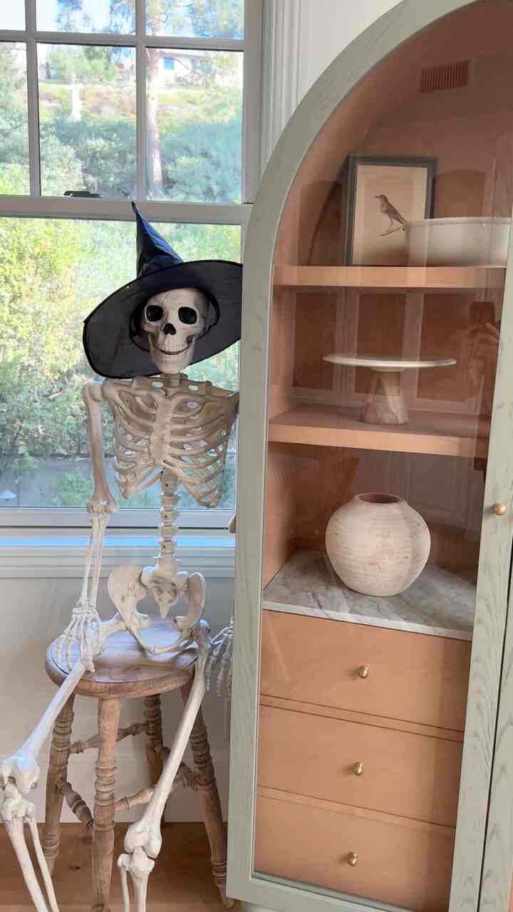 Halloween decor. #skeletonposing #halloweeninspo #archedcabinet #halloweenideas