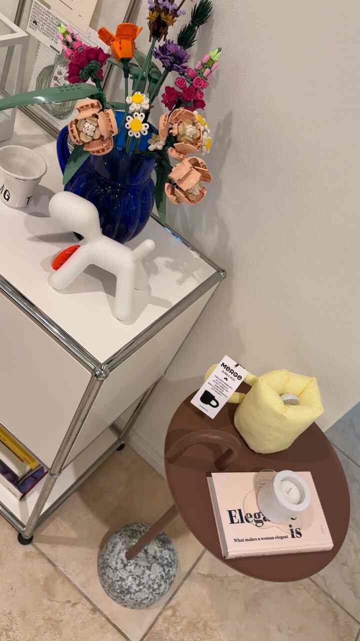 White and brown toned entrance space featuring side table, vase with flowers, and decorative objet with cozy atmosphere