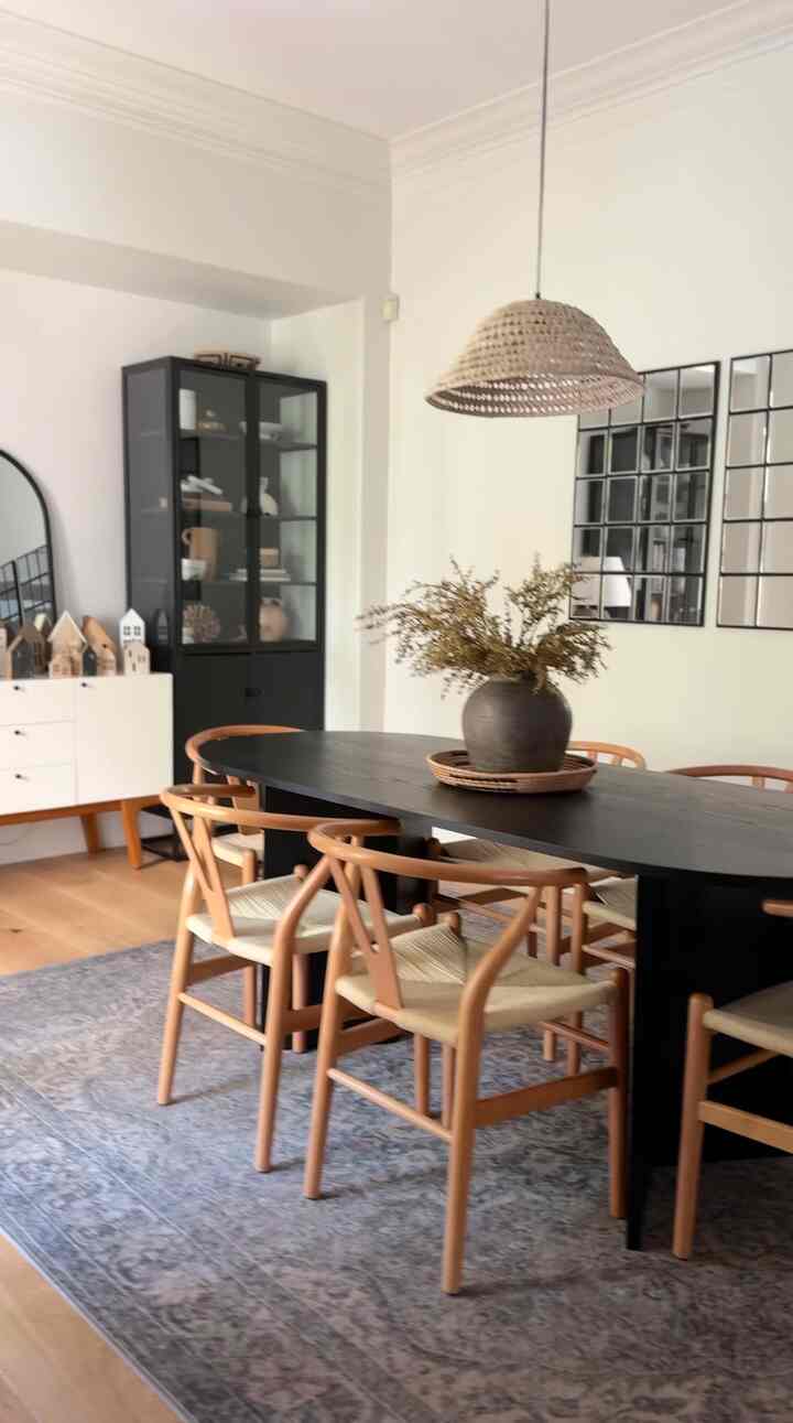 Natural tone dining room featuring a black dining table and wooden dining chairs with modern and warm atmosphere