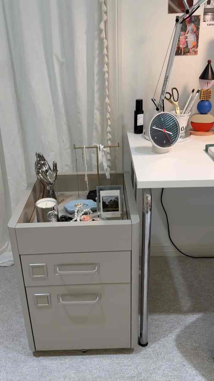 White-toned home office space featuring a beige drawer unit and clean desk in mid-century modern style