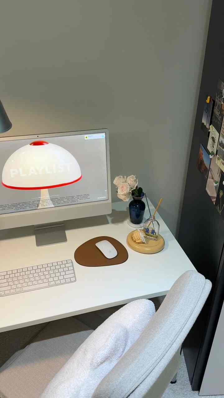 White and beige toned home office space featuring a computer monitor and comfortable chair with a clean working environment