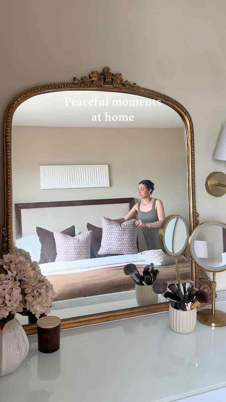 Beige-toned bedroom featuring traditional gold mirror and cushions with a peaceful atmosphere