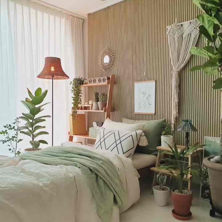 Natural-toned living room featuring a daybed used as a bed, with plants, wood shelves, and macramé decor creating a cozy atmosphere