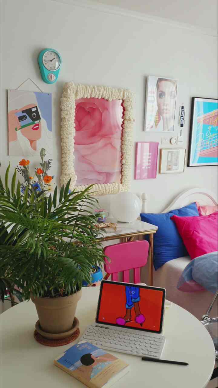 White-walled 4.5-pyeong studio bedroom featuring a round dining table, vibrant pink and blue bedding with natural plant accents