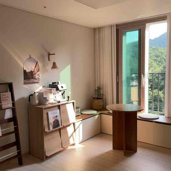 Beige and wood tone small home cafe space with window seat and storage bench by the window, creating a cozy atmosphere