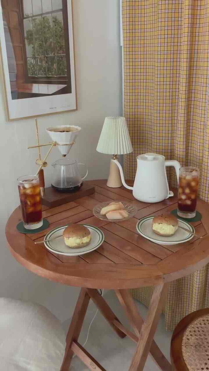 Warm wood tones and vintage atmosphere in a round kitchen space featuring a home cafe coffee setup, tea, and snacks on a cozy dining table