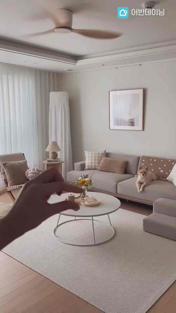 Beige-toned living room featuring a sectional sofa, lounge chair, and white round coffee table in a natural modern style