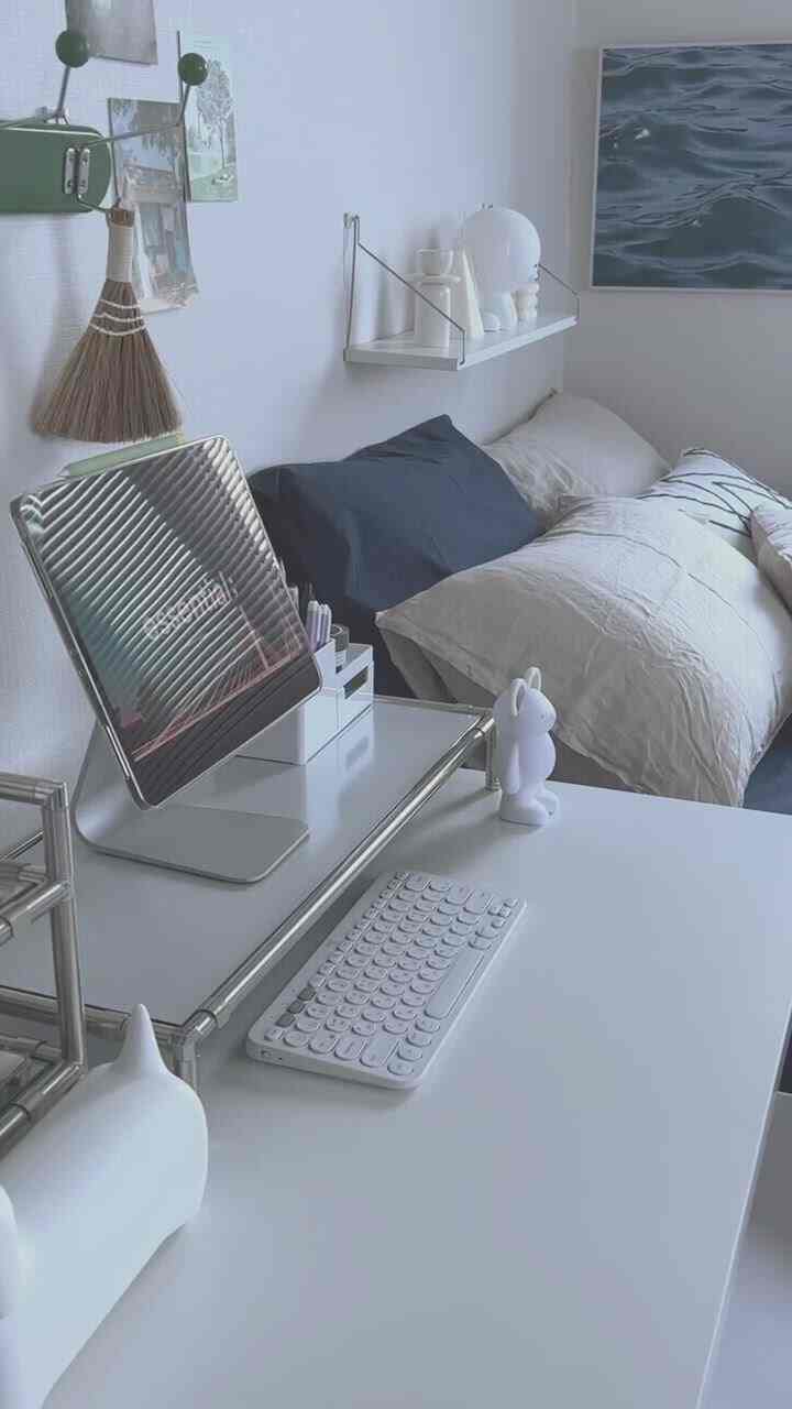 White and gray toned studio apartment home office featuring a desk and bed with a clean, modern, and compact interior