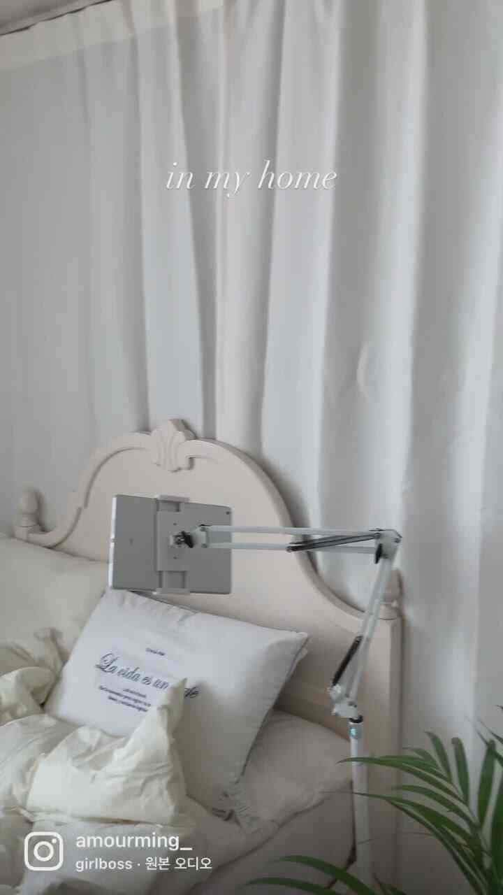 White-toned bedroom featuring soft bedding, decorative bed frame, and blackout curtains creating a cozy atmosphere