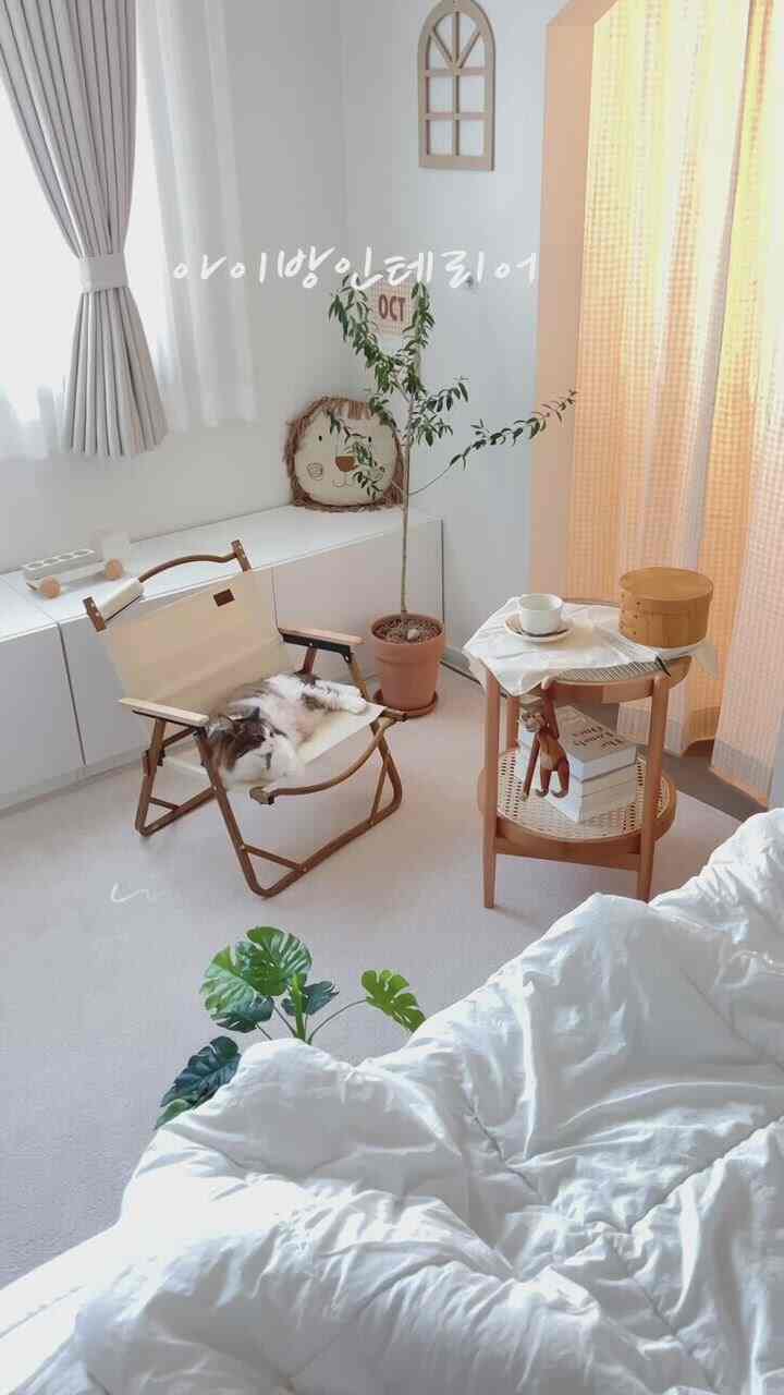 白と木目調の調和が取れた子供部屋、ナチュラルで温かみのあるインテリアに猫が休んでいる