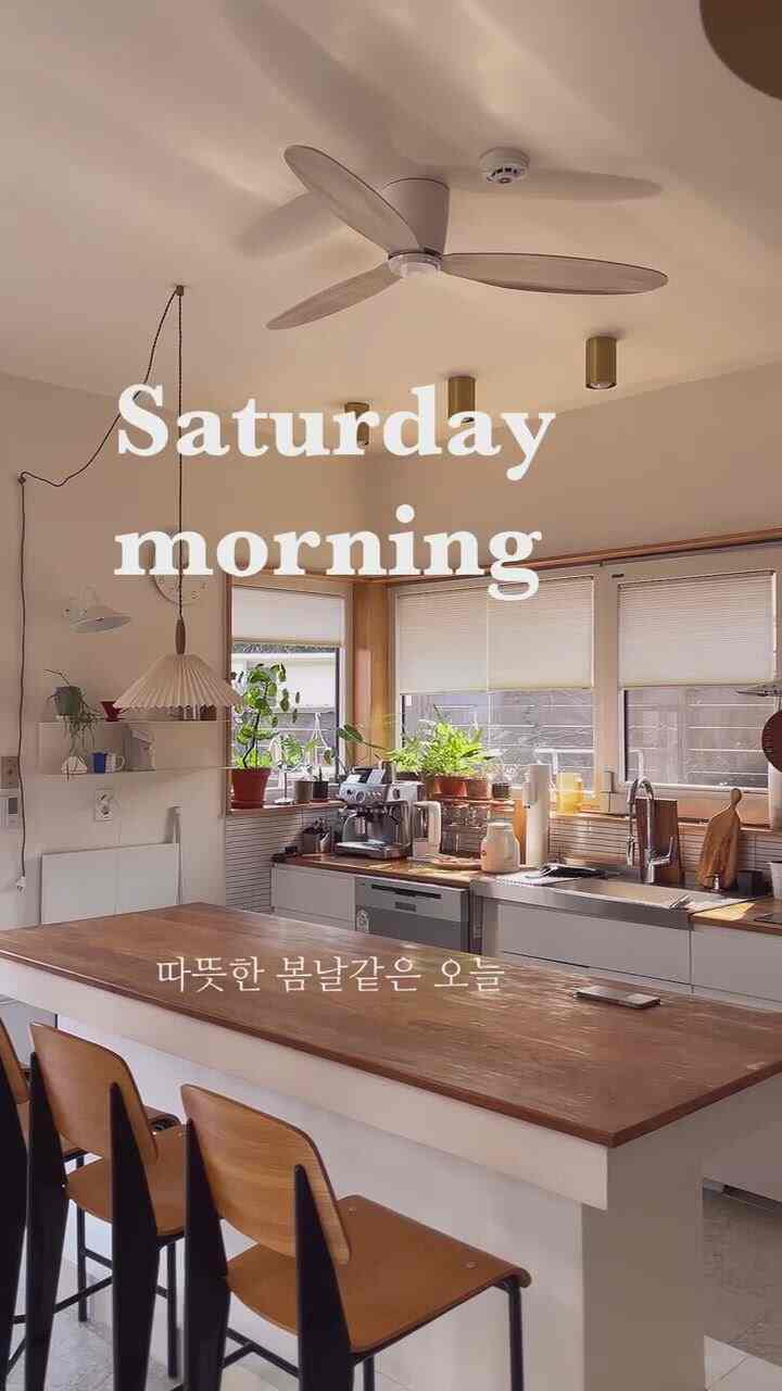 暖かいナチュラルな木目調のキッチン空間、大きなキッチンアイランドと木製チェアが落ち着いた雰囲気を醸し出すインテリア