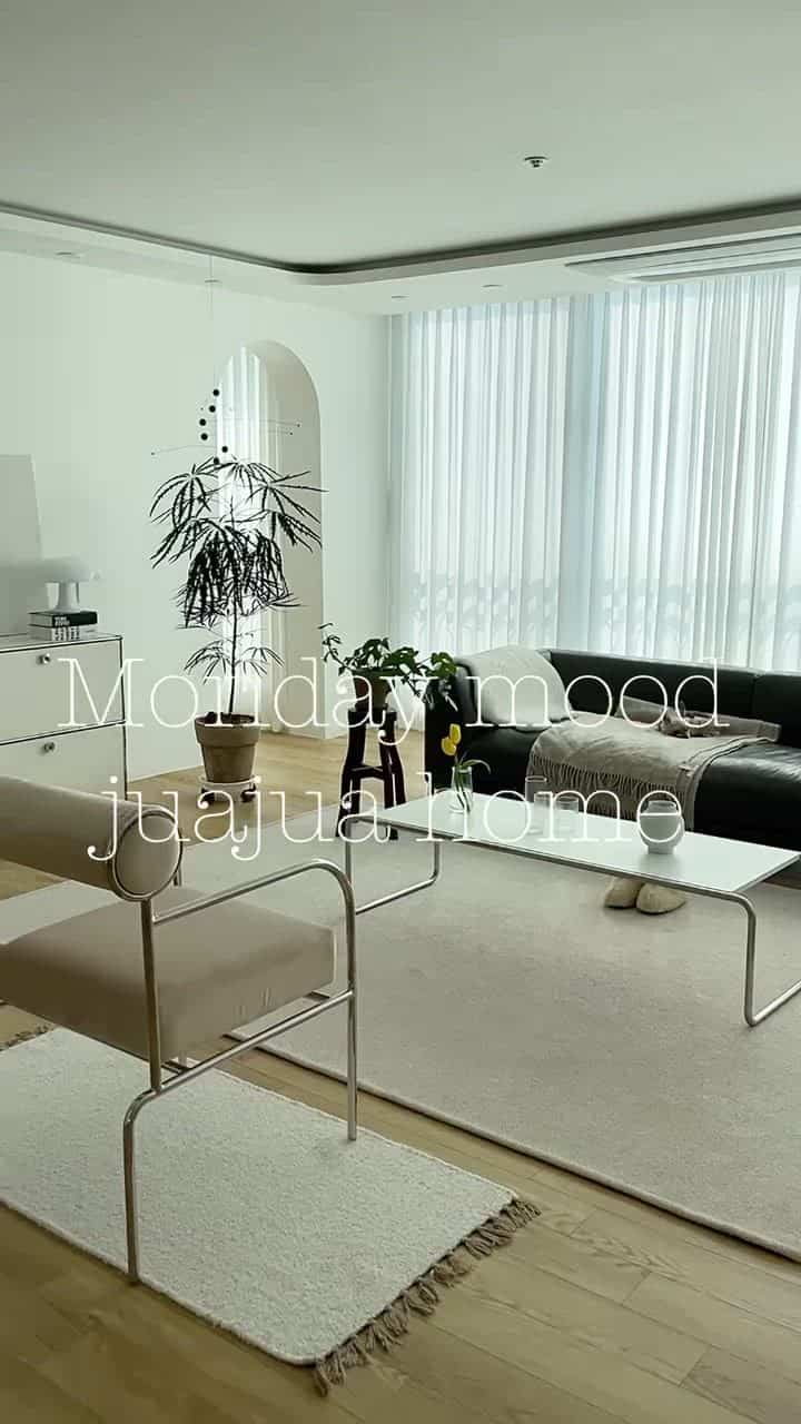 Modern living room in white and wood tones featuring a cat and armchair with a calm atmosphere