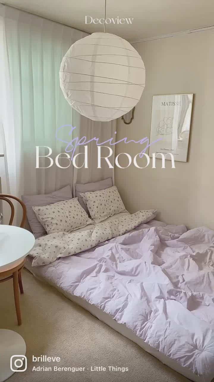 Pastel-toned bedding and white curtains in a simple, cozy bedroom space