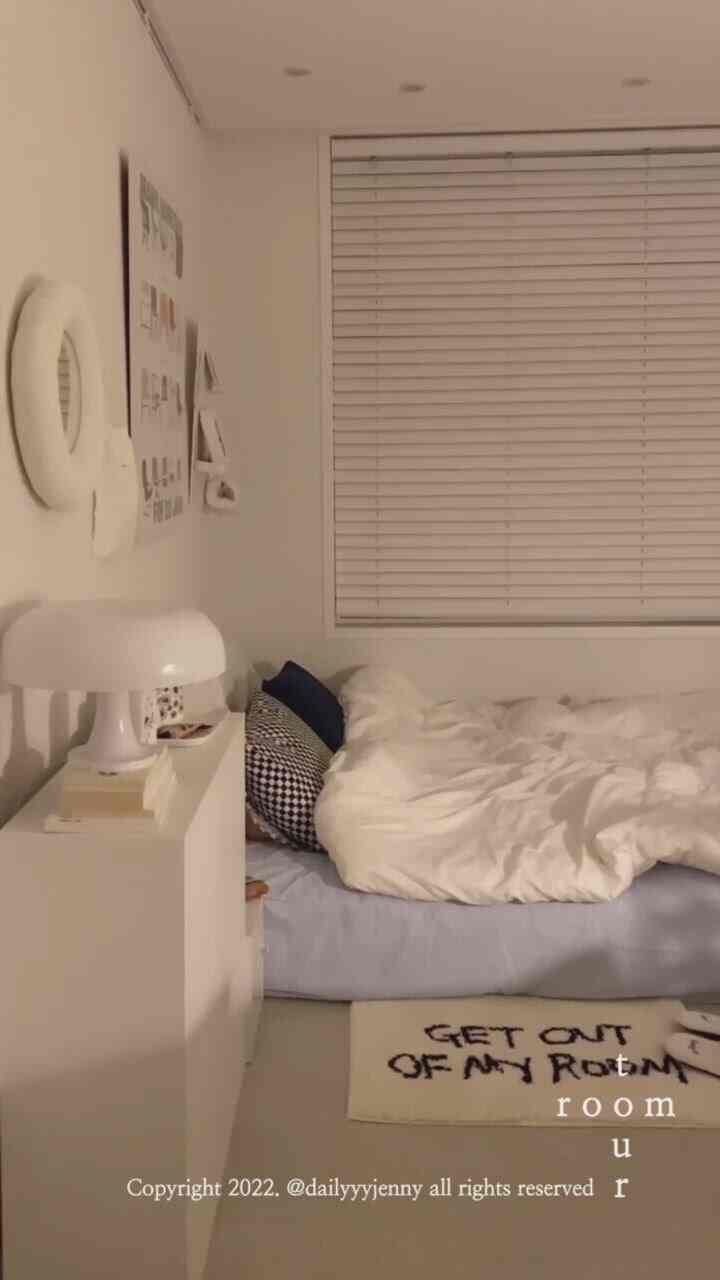 White-toned single household bedroom featuring a bed, nightstand, and blinds with a simple, modern atmosphere