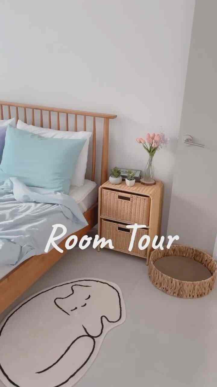 Pastel-toned bedroom with natural wood furniture featuring cat-themed decor and a cozy atmosphere