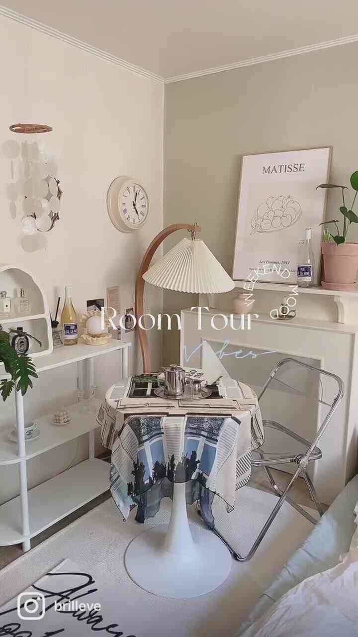 ベージュと白を基調としたナチュラルなリビング、丸テーブルと透明な椅子が配された雰囲気のあるカフェ風インテリア