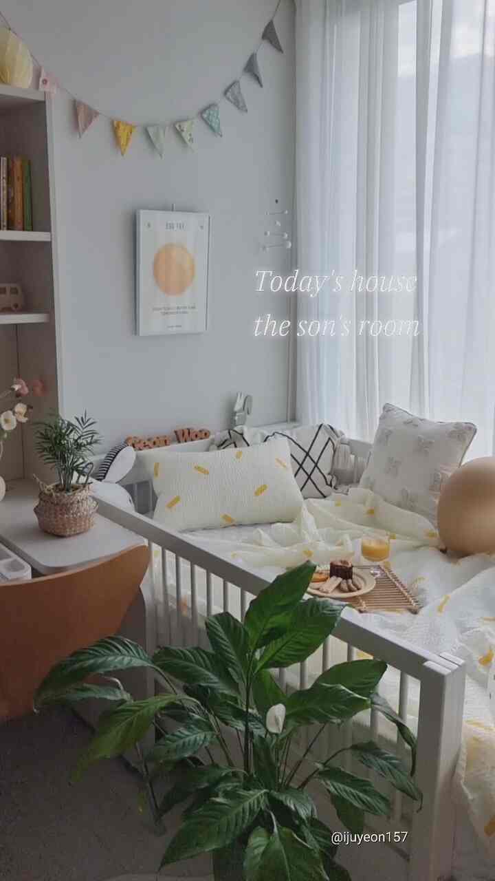 明るいホワイトトーンの壁とレモンイエローの寝具がある子供部屋、ポスターやガーランド、植物が配置された爽やかなインテリア