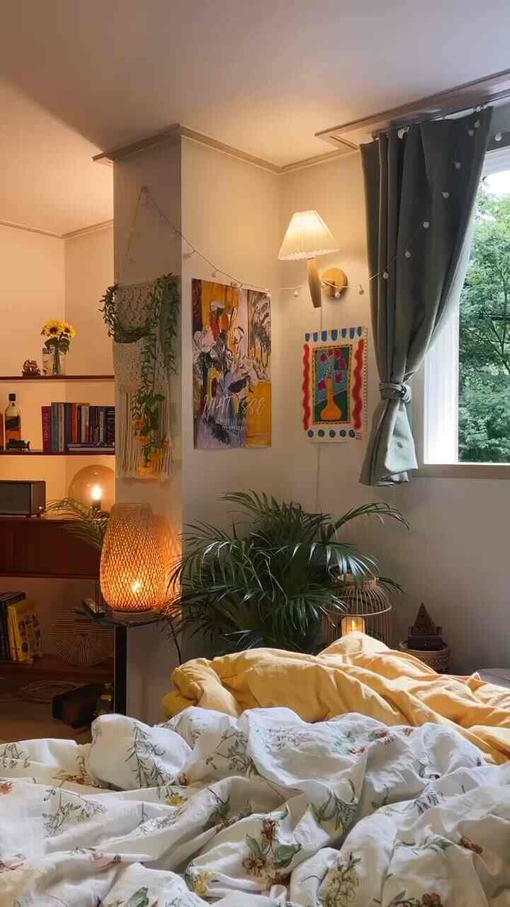 Cozy beige-toned bedroom featuring green plants and floral yellow bedding with warm lighting