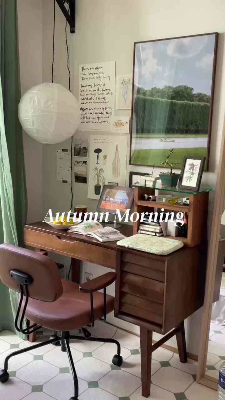Wood tone home office featuring a wooden desk, pink office chair, and pendant light creating a peaceful autumn morning mood