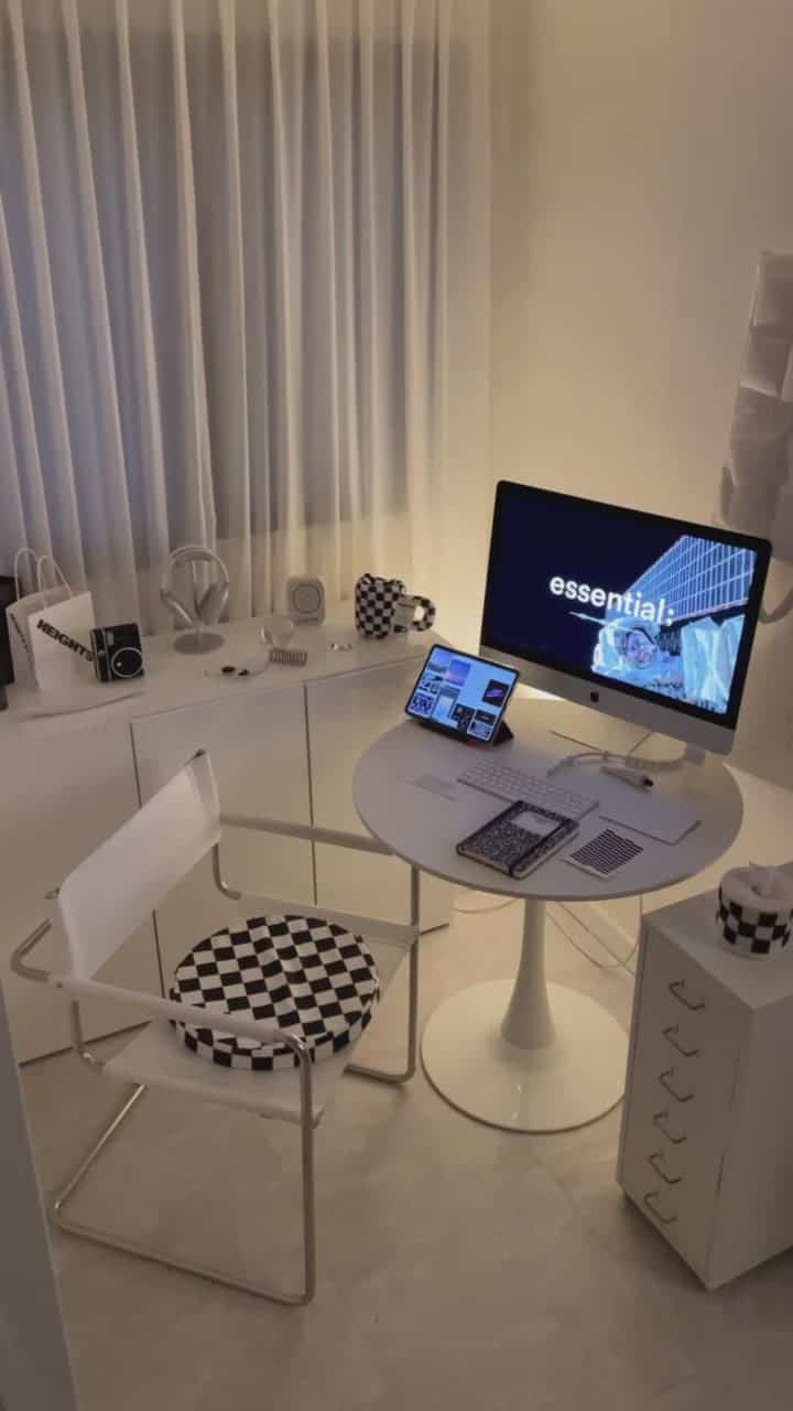 White-toned studio apartment home office space featuring round table and checkered chair with a clean modern interior