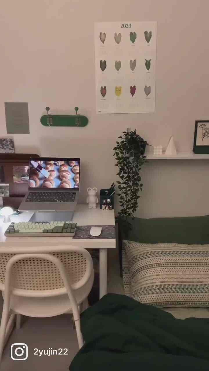 White and green toned bedroom with desk and chair arranged in a minimal home office space