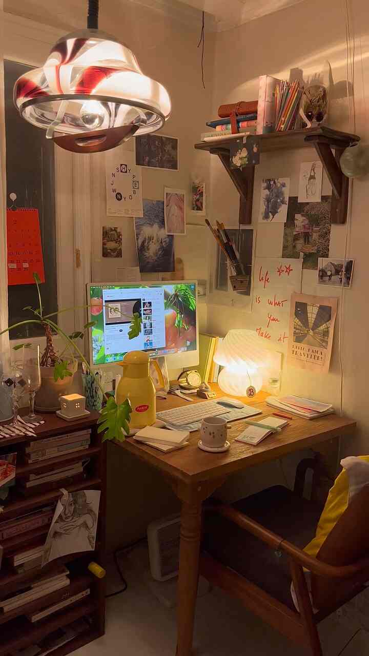 ナチュラルな木目調とヴィンテージ照明が調和したワンルーム作業室、木製デスクと植物が配置された居心地の良いホームオフィス