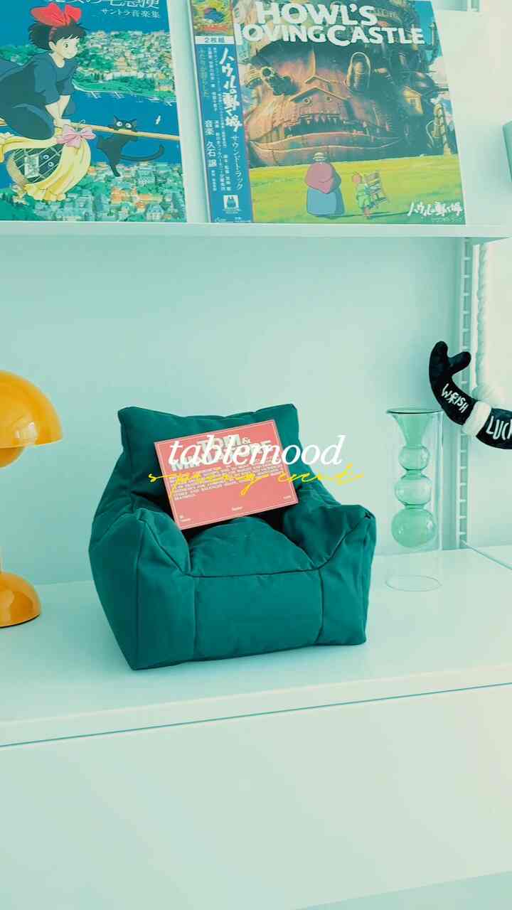 黄色い花と水彩画風の花瓶が置かれたミニマルなリビングの棚のインテリア