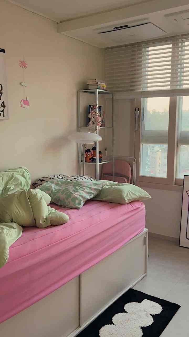 白とナチュラルカラーの寝室、コンパクトなベッドと枕が配置されたシンプルで落ち着きのある雰囲気のあるインテリア