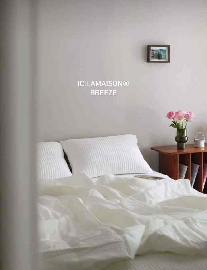 明るいホワイトトーンの寝室、白い寝具と枕、ナチュラルな木製ドレッサーが調和したシンプルなインテリア