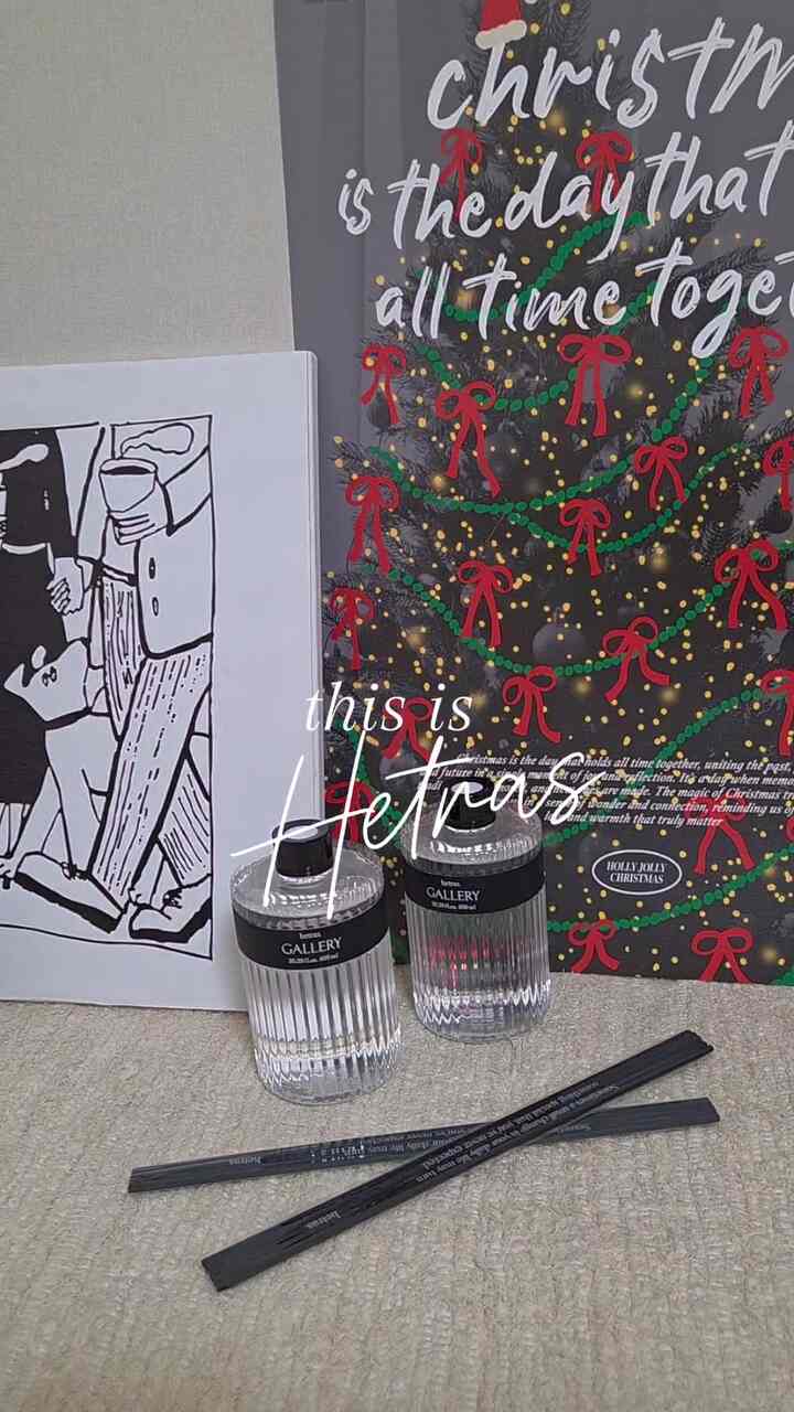 ホワイトとブラックの色調のインテリア、クリスマスポスターとディフューザーのオブジェが配置された印象的な空間